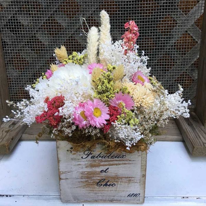 Caja de madera vintage con flores secas y preservadas