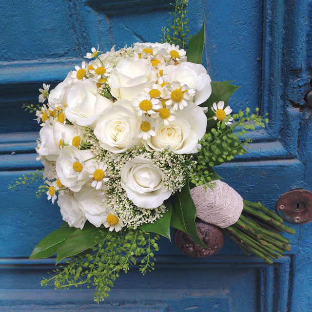 Ramo de novia fresco y elegante en tonos blancos, compuesto por rosas blancas y tanacetum