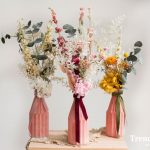 Jarrones de vidrio rosa con flores preservadas