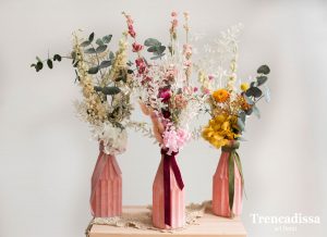 Jarrones de vidrio rosa con flores preservadas