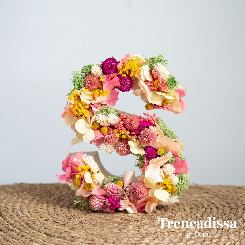 Letra decorada con flores secas y preservadas en tonos rosa, beis y un toque de verde