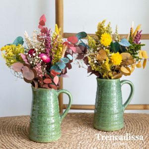 Jarrones de cerámica esmaltada verde con flores secas y preservadas