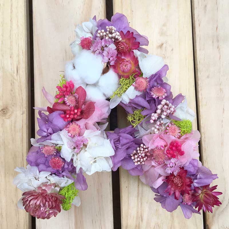 LILAC, letra decorada con flores secas en tonos lilas, blancos y rosas
