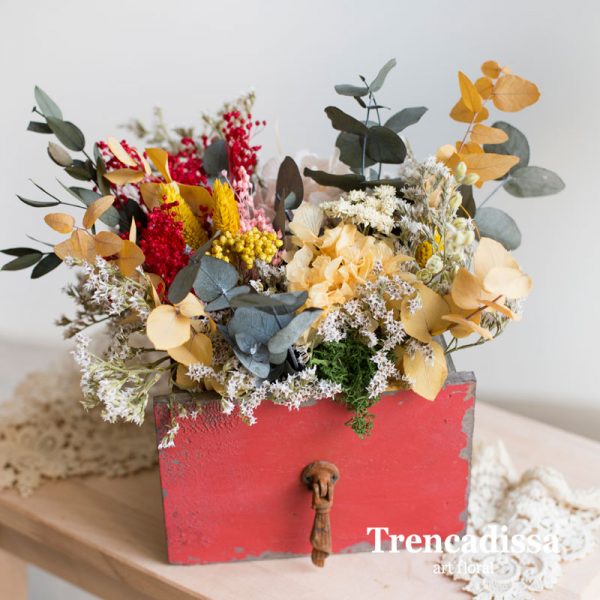 Caja de madera roja con flor seca y preservada