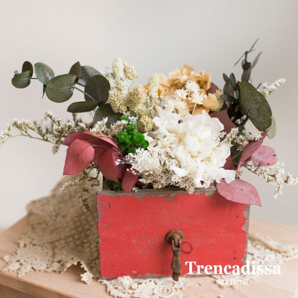 Caja de madera roja con flor seca y preservada