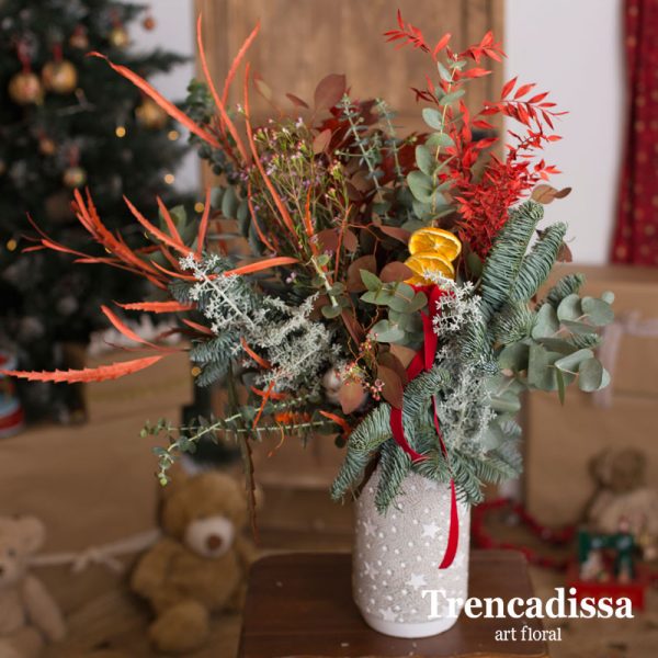Ramo de navidad natural en un jarrón de cemento con notas navideñas, ideal para decorar y perfumar cualquier espacio.