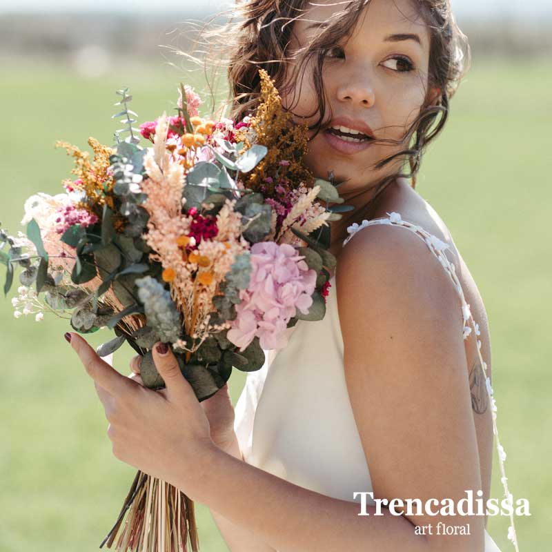 Bouquet desenfadado con un estilo silvestre en tonos lilas y fucsia. Empuñadura de puntilla blanca.