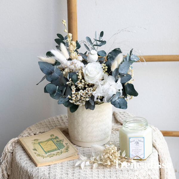 Recipiente cerámico decorado con flor seca y preservada.