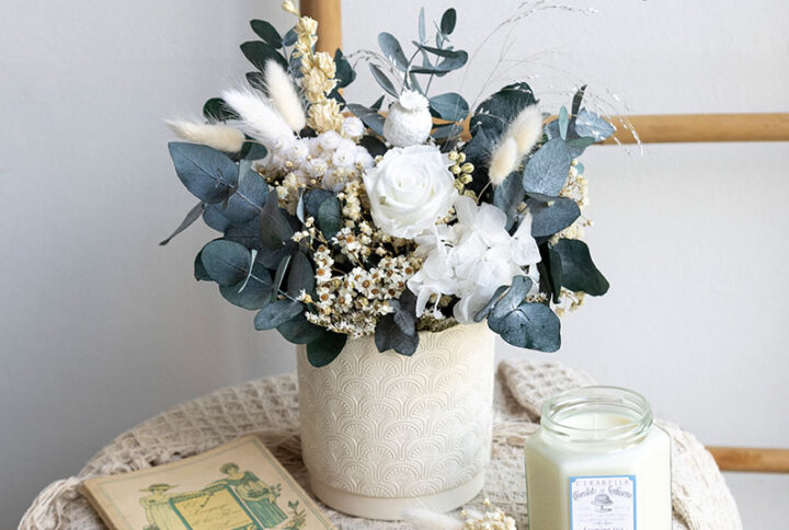 Recipiente cerámico decorado con flor seca y preservada.