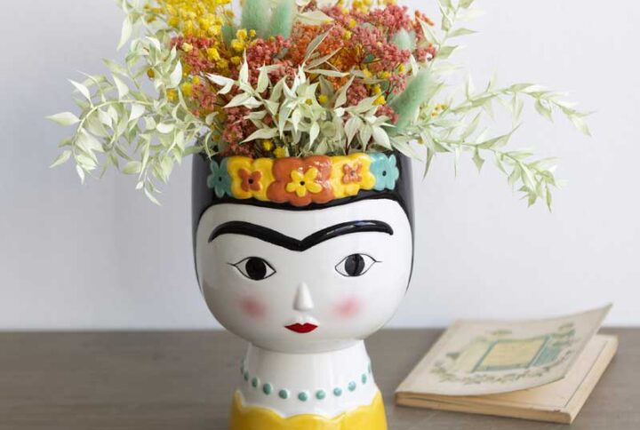 Jarrón con rostro de mujer con flores secas y preservadas