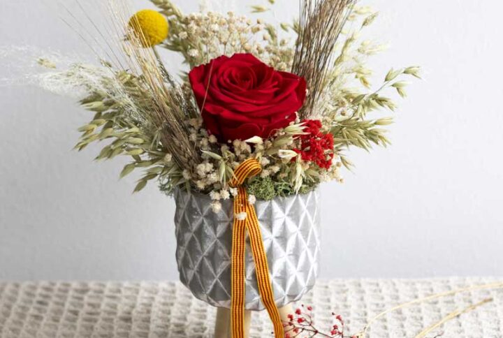 Recipiente de cerámica decorado con rosa preservada y flor seca: