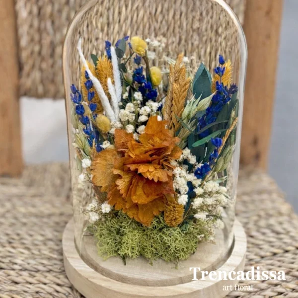 Cúpula de vidrio con flor seca variada.