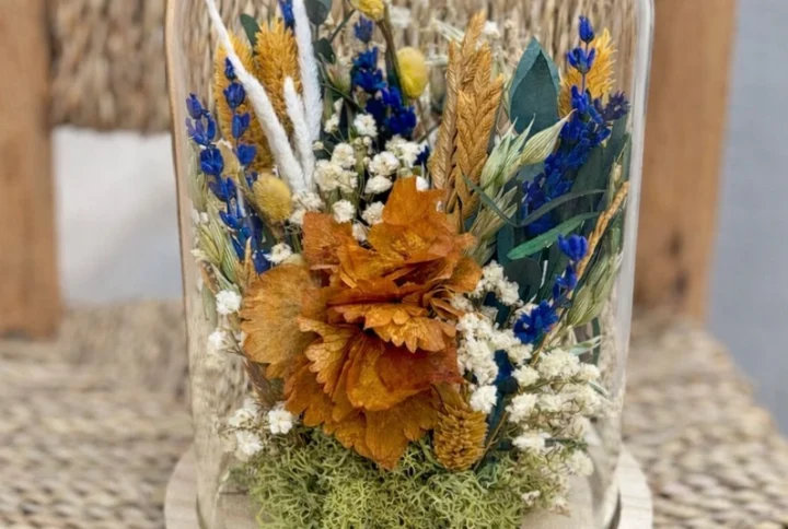 Cúpula de vidrio con flor seca variada.